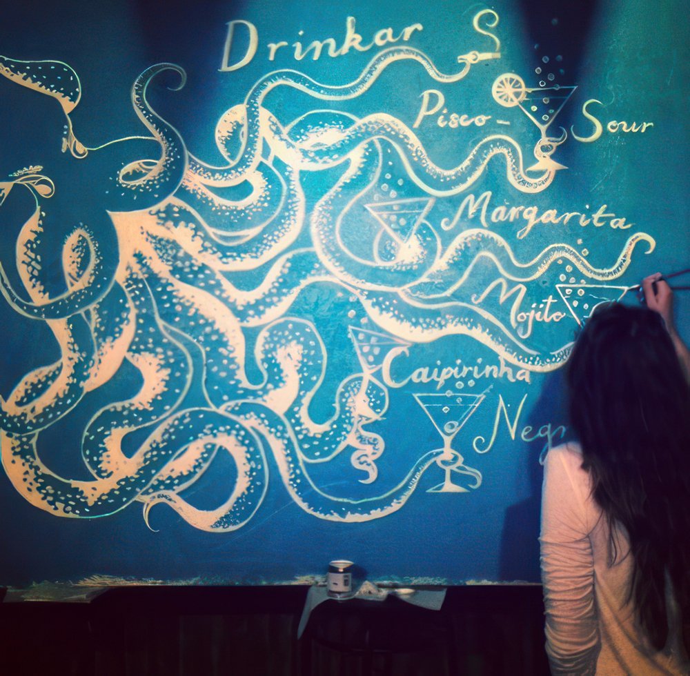 a woman drawing a drawing on a wall