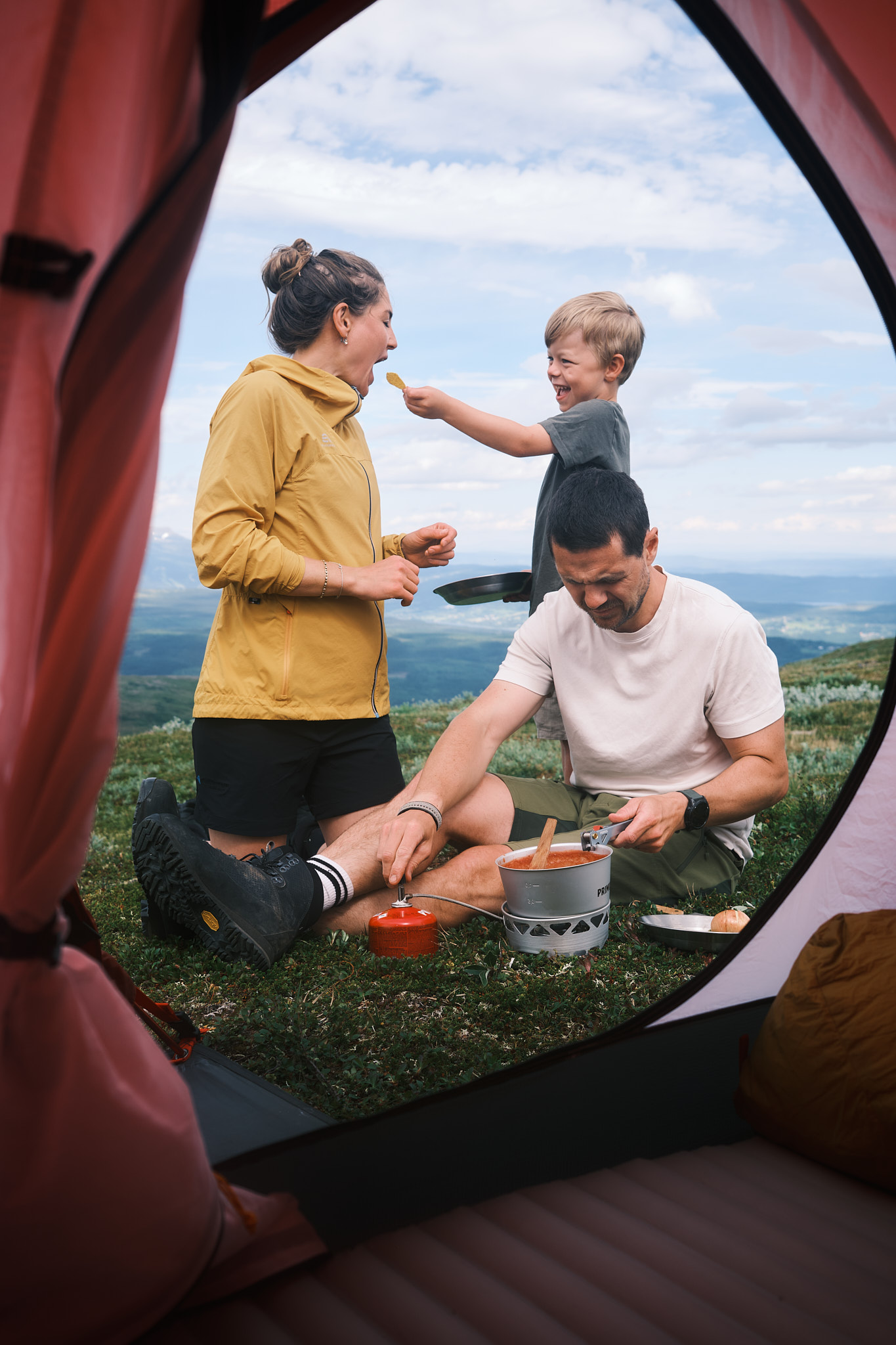 a man and woman with a child eating food outside