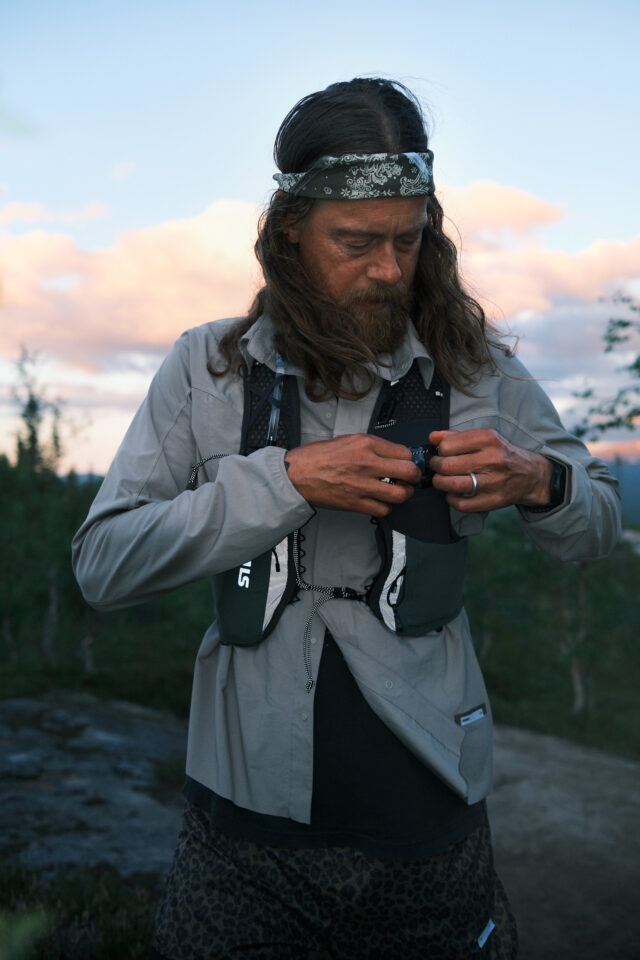 a man with long hair and a bandana looking at his phone