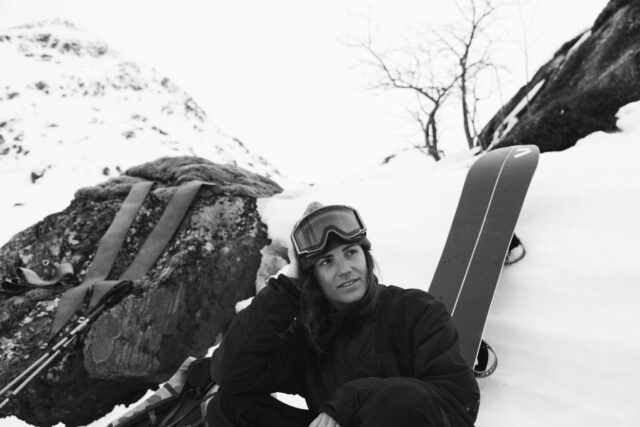 a woman sitting in the snow with skis