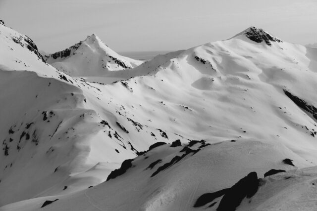 Snow-covered mountains under a bright sky.