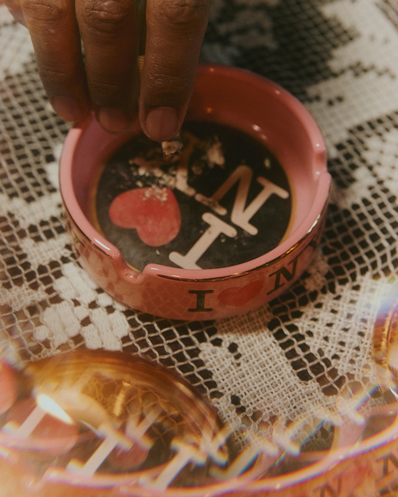 a hand putting a cigarette in a ashtray