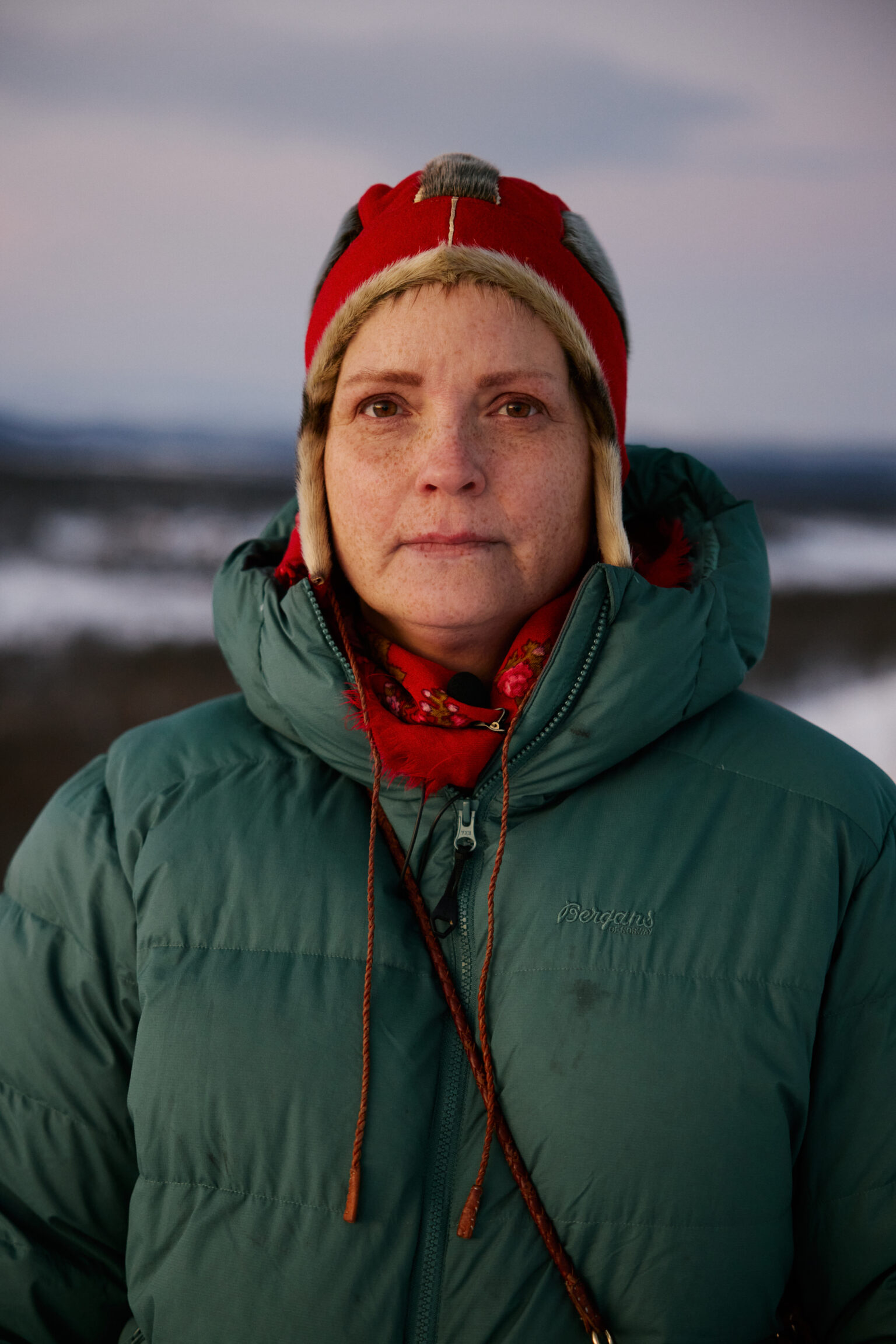 a woman in a green coat and red hat