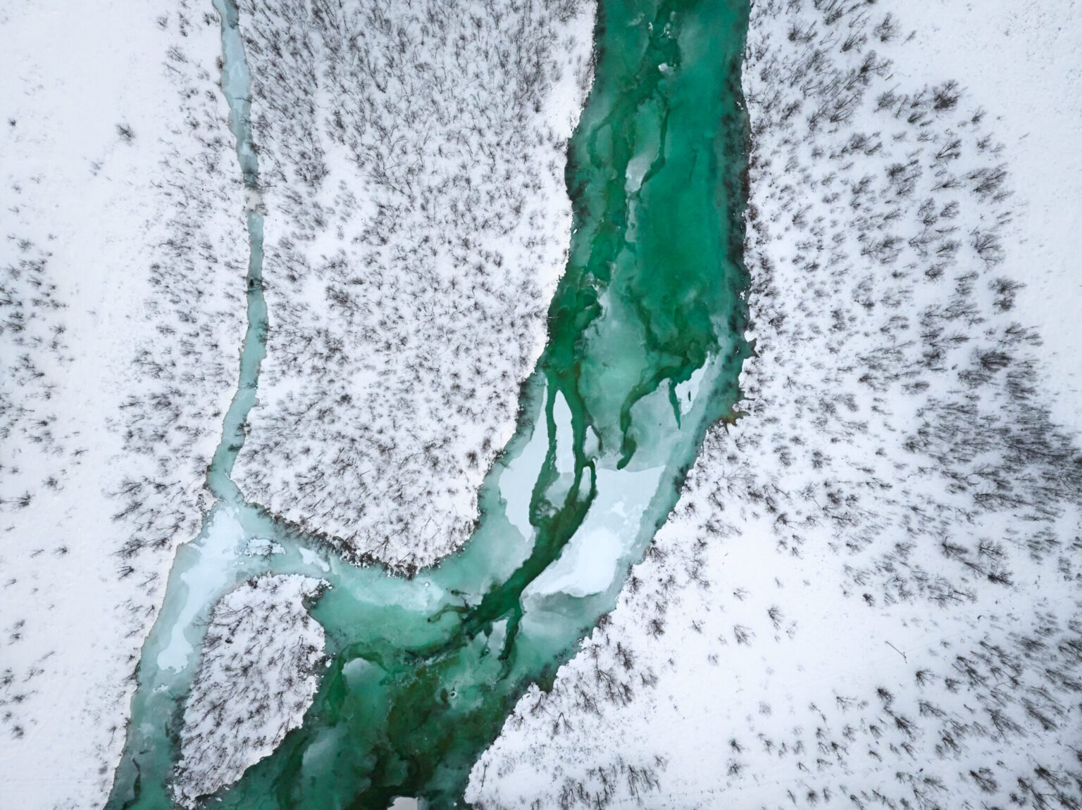 a river flowing through a snowy area