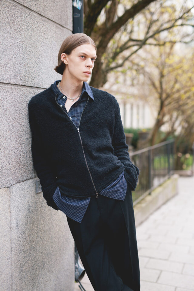 a man leaning against a wall