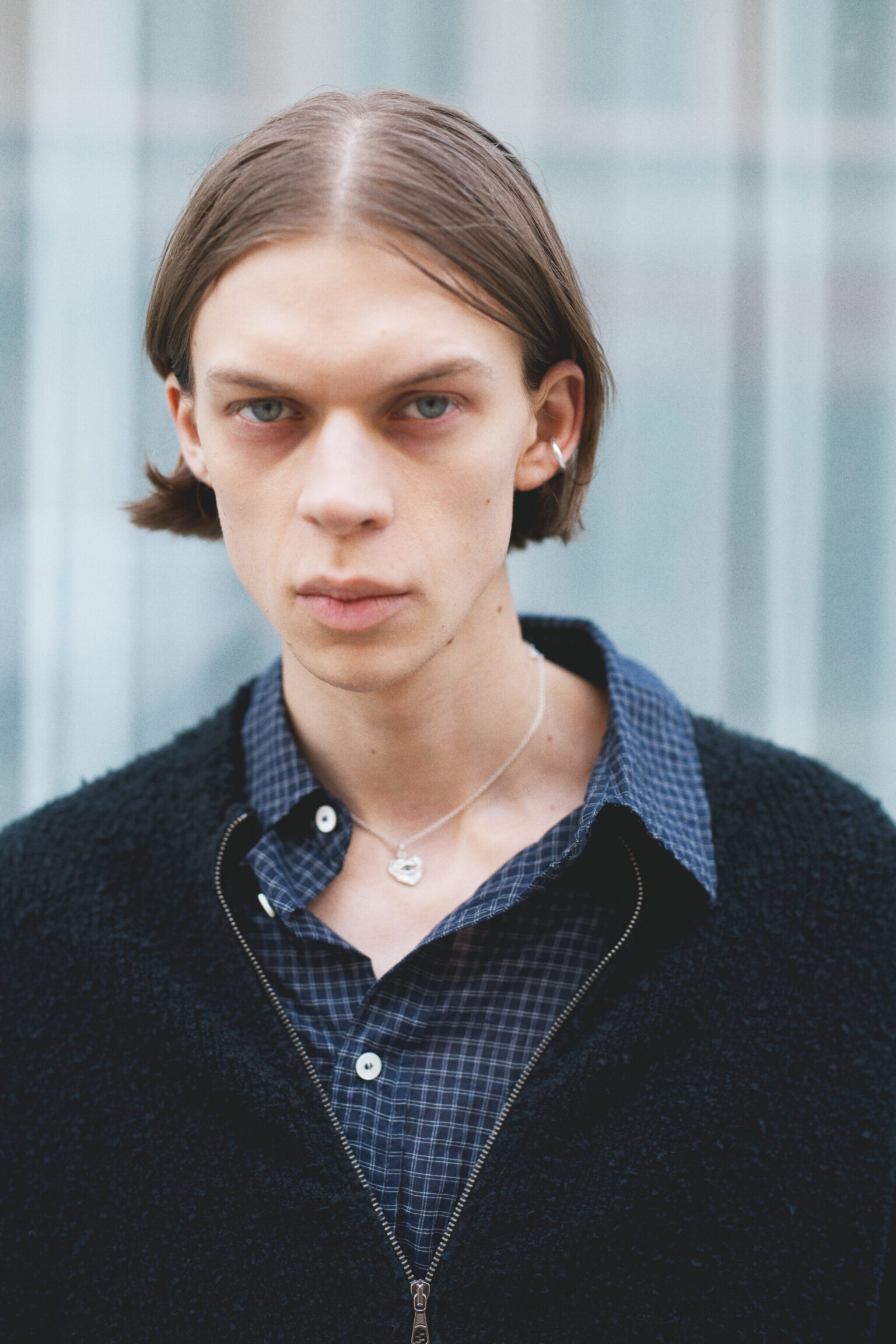 a man with long hair wearing a black jacket