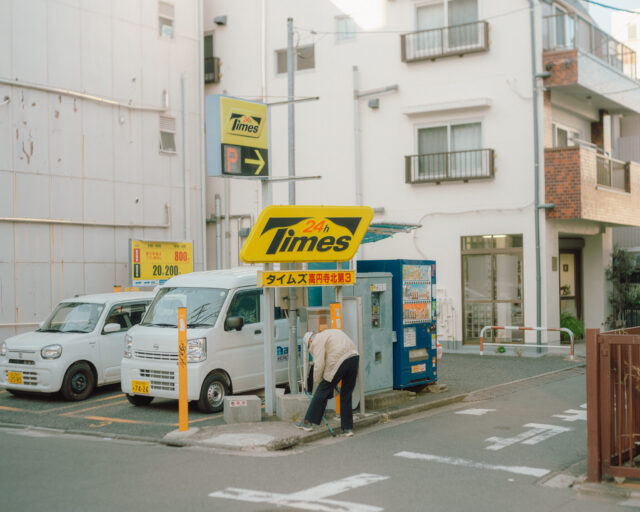 a man leaning against a sign