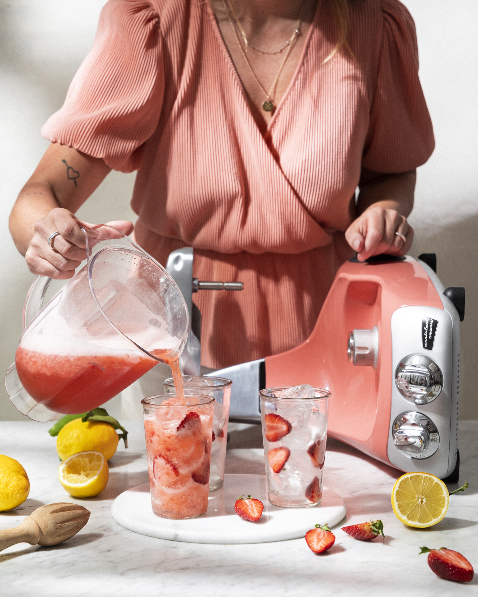 a woman pouring a drink into glasses