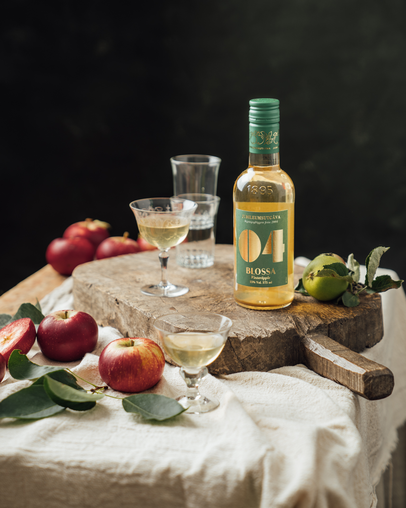 a bottle of liquor and glasses on a cutting board