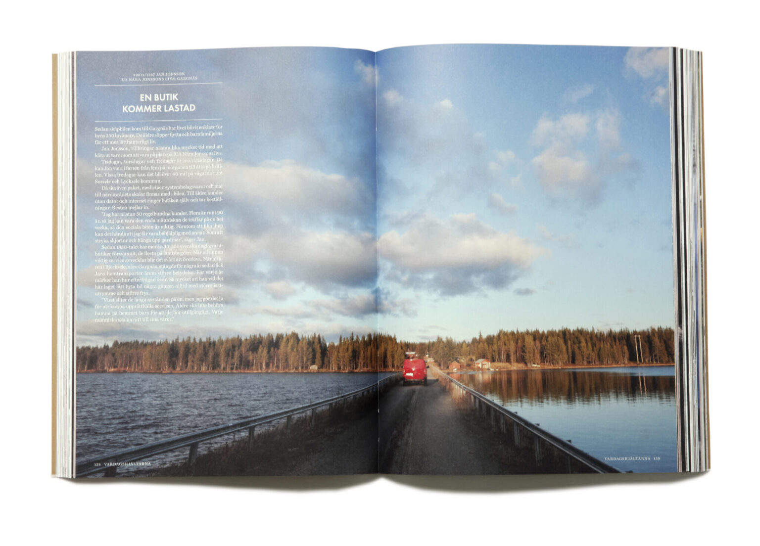 an open book with a picture of a lake and a red car