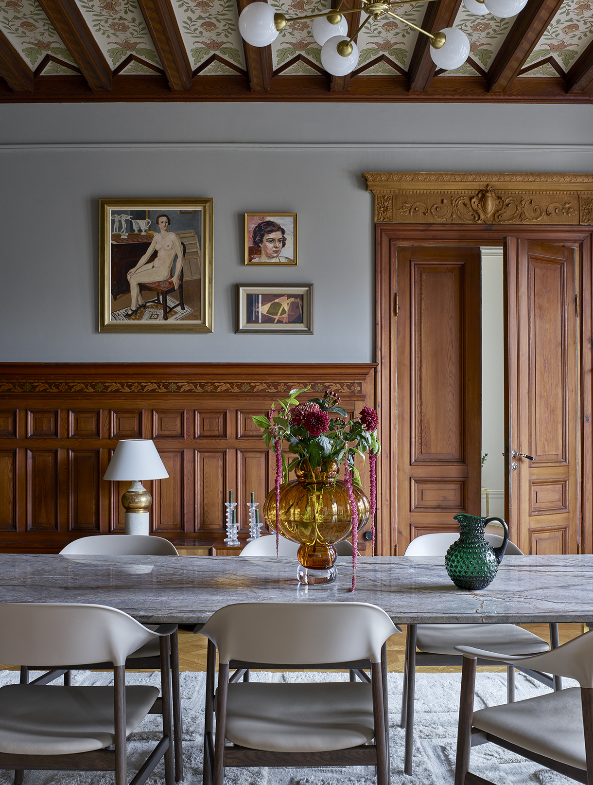 a table with chairs and vase on it
