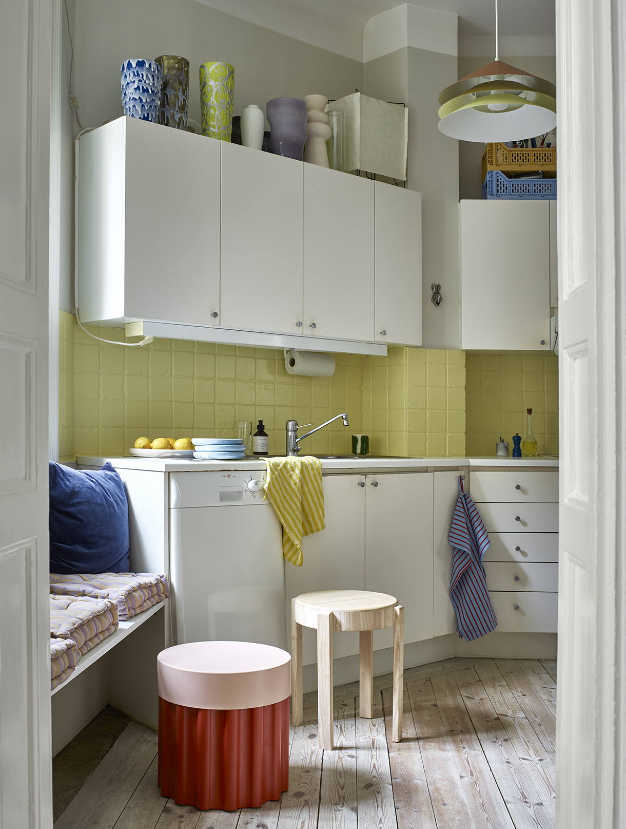 a kitchen with white cabinets and yellow walls