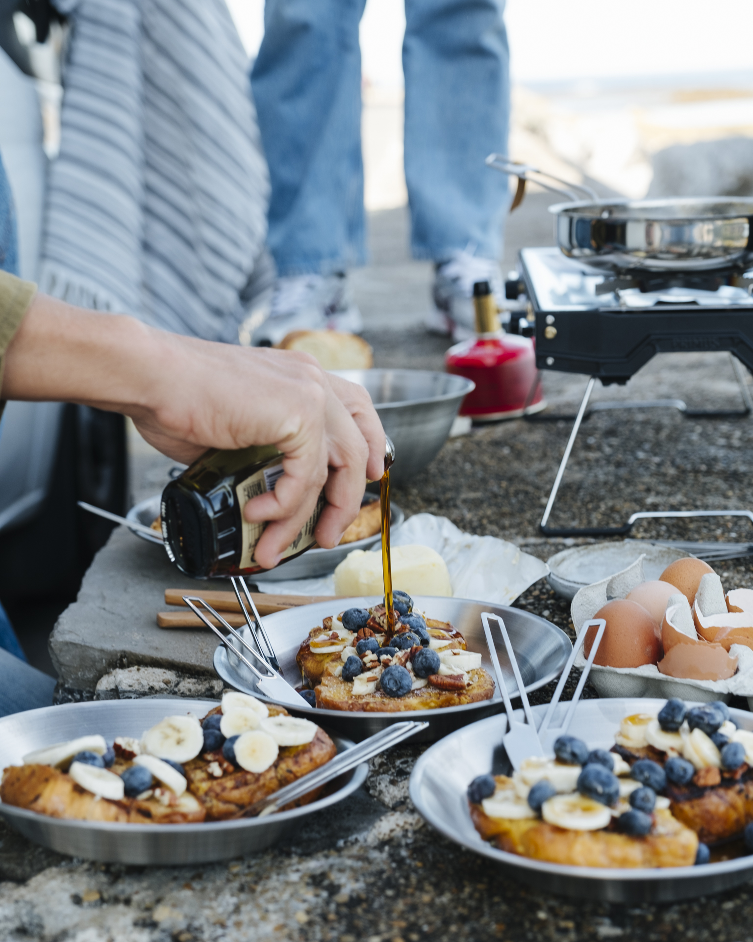 a person pouring syrup on food
