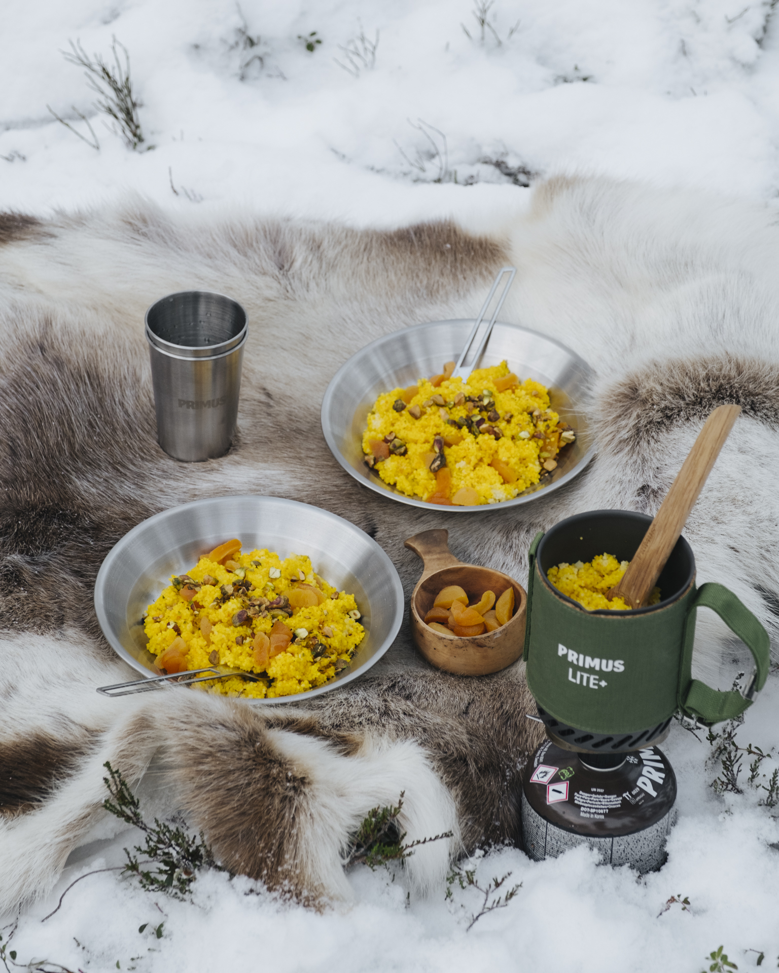 food in bowls on a fur rug in the snow