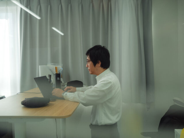 a man sitting at a desk using a laptop
