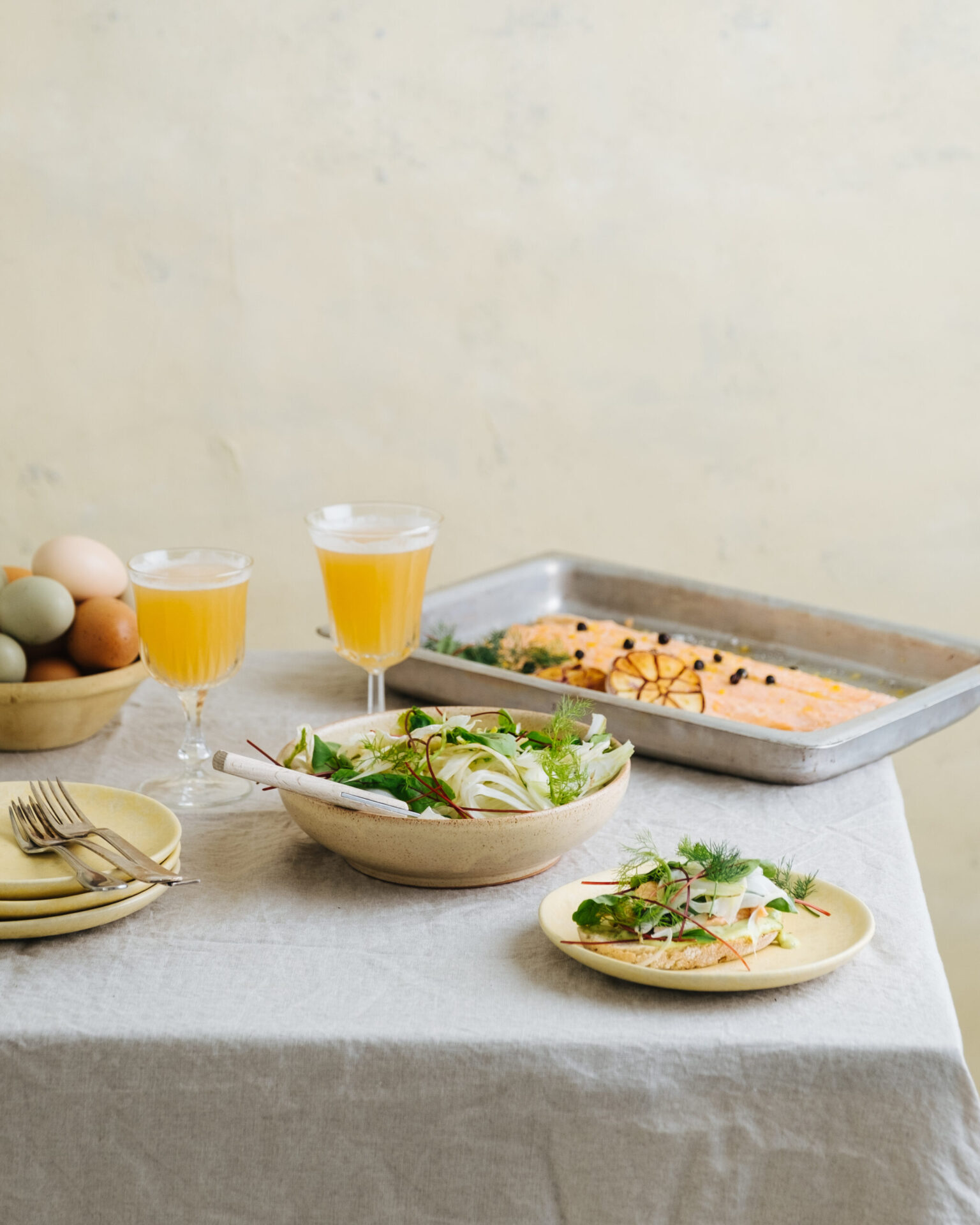 a table with plates of food and glasses of juice