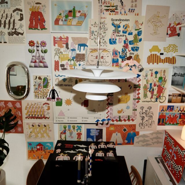 a room with a table and a table with a lamp and pictures on the wall