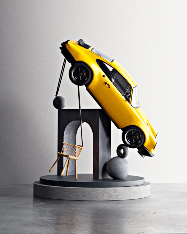 Yellow car balanced precariously on abstract sculptures and a small wooden chair.