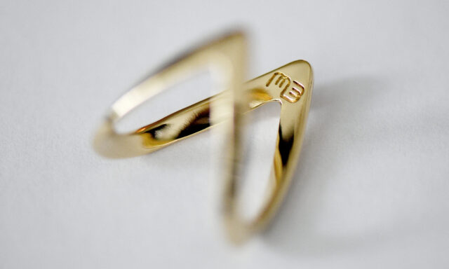 Gold ring with "me" logo.